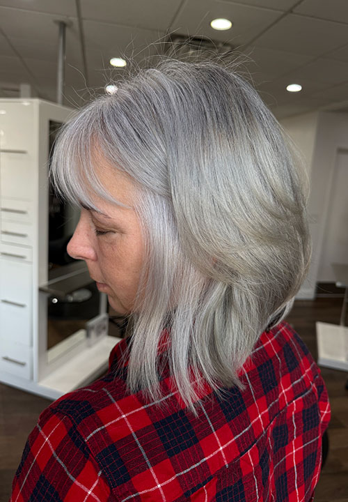 Soft layered silver gray hair, side view.