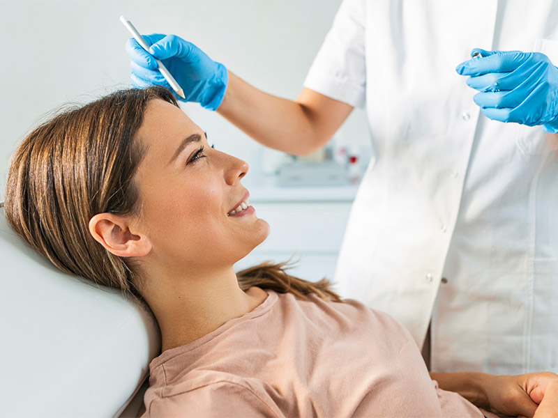 Doctor measuring a women's face.