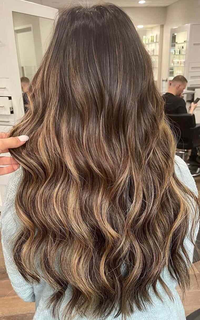 Back view of wavy hair highlights style change at Elavína Salon and Spa.