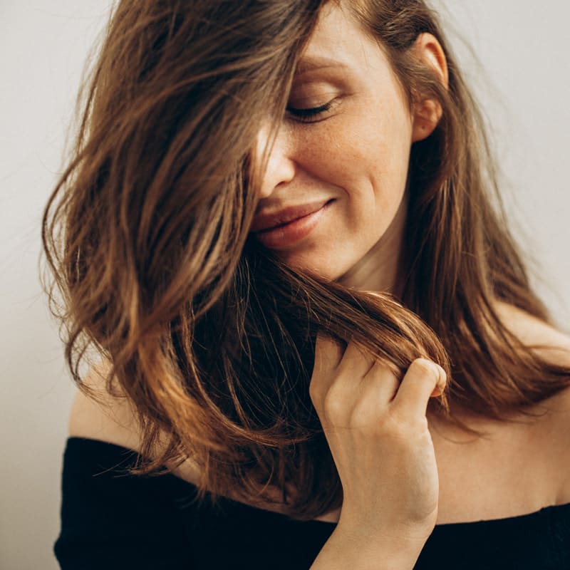 A woman with her open hair enjoys a salon experience at Elavína Salon and Spa in Manchester, NH.