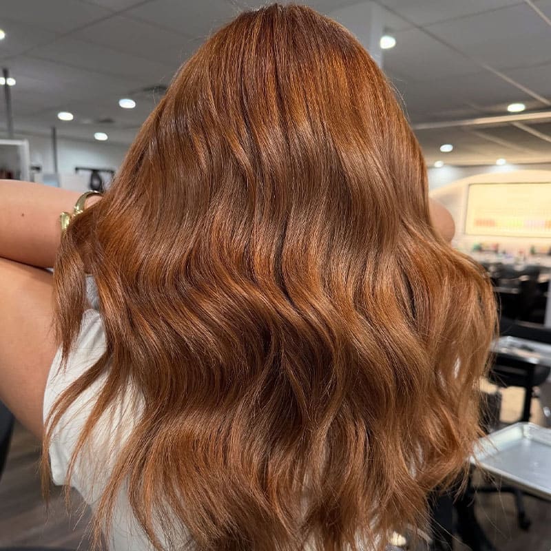 Woman with wavy red hair in Elavína Salon and Spa in Manchester, NH.